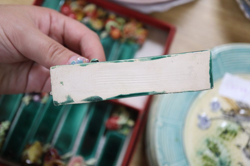 A set of six French earthenware plates, faience plates etc and pottery knife rests